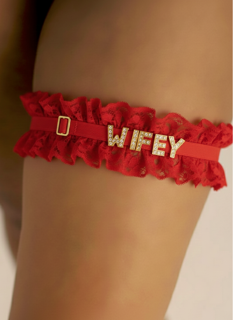Red garter belt with 'WIFEY' in gold letters on a beige background
